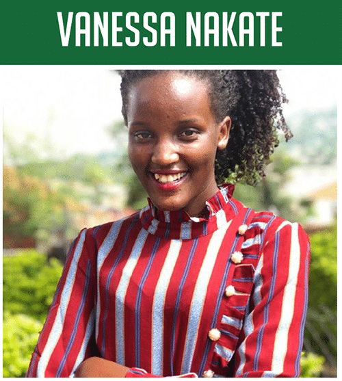 vanessa1 Smiling woman with curly hair wearing a red and white striped blouse with gold buttons outdoors.